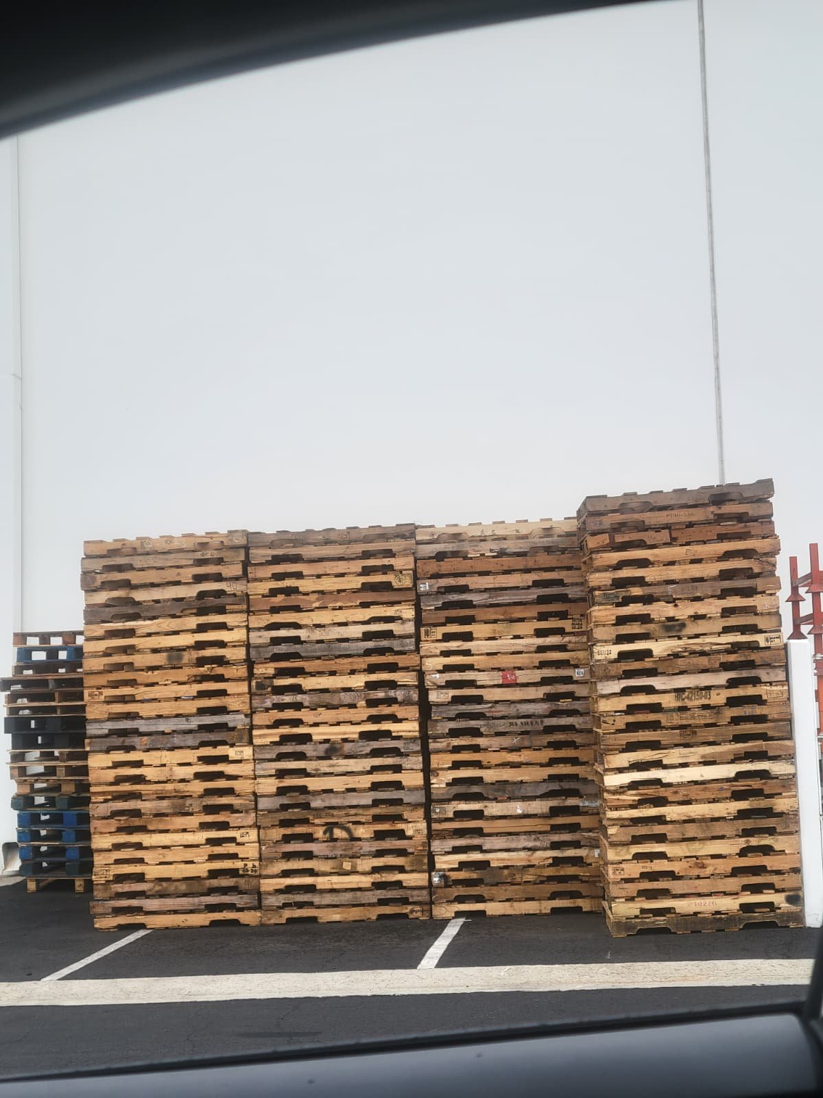 Stacks of used pallets ready for buyback at a Los Angeles pallet yard