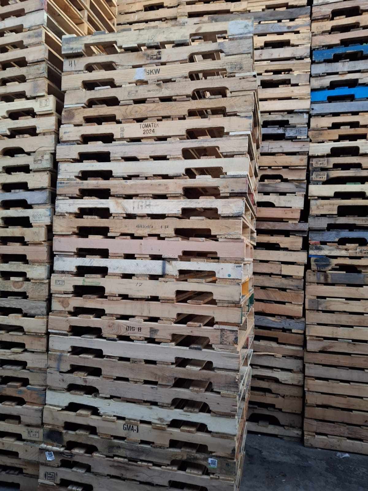 Recycled used pallets compared to new pallets showing condition differences